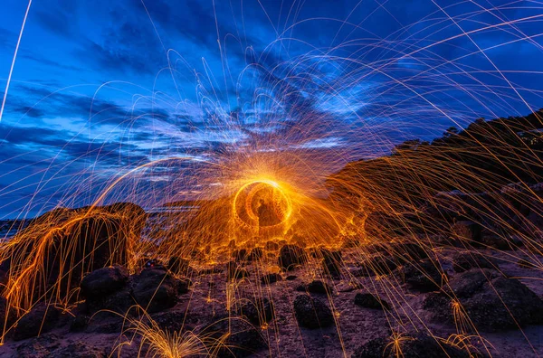 cool burning steel wool fire work photo experiments on the rock at sunrise