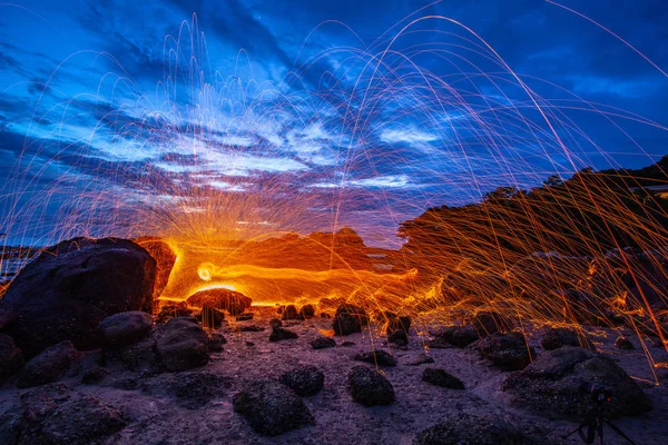 cool burning steel wool fire work photo experiments on the rock at sunrise