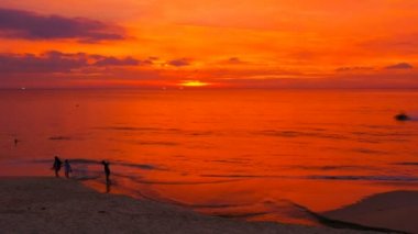 turistler denizden Karon adlı muhteşem gün batımı sırasında sahilde Phuket beach