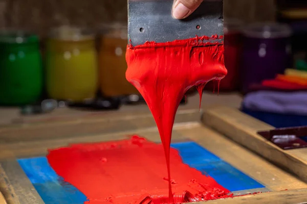 El serigrafi baskı tee gömlek tee gömlek fabrikası sırasında damlayan kırmızı renk.