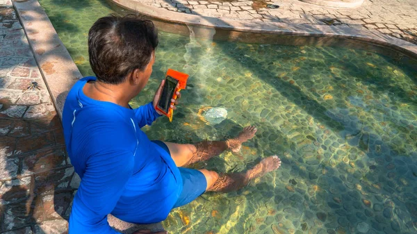 Een Man Kijken Mobiele Tijdens Hete Lente Bad — Stockfoto