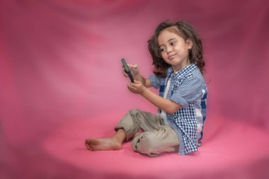 bir çocuk selfie onun cep telefonuna pembe bir arka plan ile