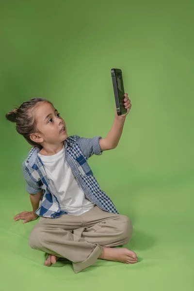 Yeşil Zemin Üzerine Cep Ile Uzun Saçlı Çocuk Selfie — Stok fotoğraf