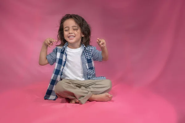 Ein Glücklicher Junge Mit Langen Haaren Sitzt Rosa Hintergrund — Stockfoto