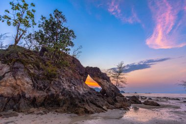 Phayam adası Ranong Tayland Hin Thalu Buffalo plajda orta huzurlu atmosferde bir delik ile kemer gibi kavite içine aşınmış alışılmadık kaya dalgası delik güzel gün batımı