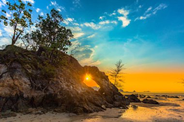 Phayam adası Ranong Tayland Hin Thalu Buffalo plajda orta huzurlu atmosferde bir delik ile kemer gibi kavite içine aşınmış alışılmadık kaya dalgası delik güzel gün batımı