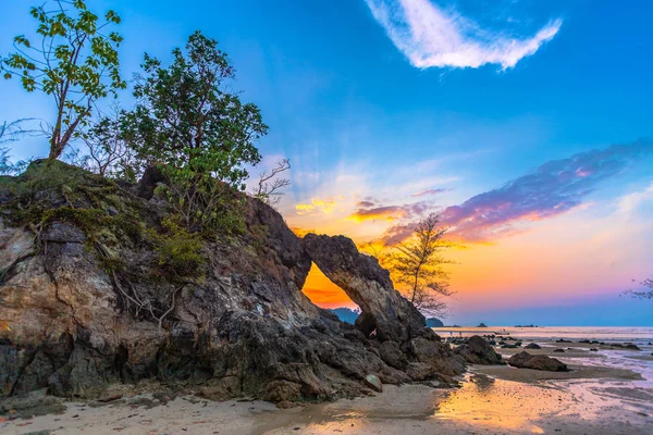 beautiful sunset in the hole of unusual rock wave eroded into the cavity like the arch with a hole in the middle peaceful atmosphere at Hin Thalu Buffalo beach on Phayam island Ranong Thailand