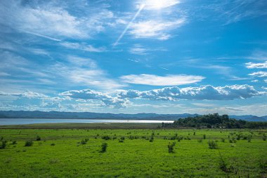 mavi gökyüzünde baraj yanında büyük yeşil alan