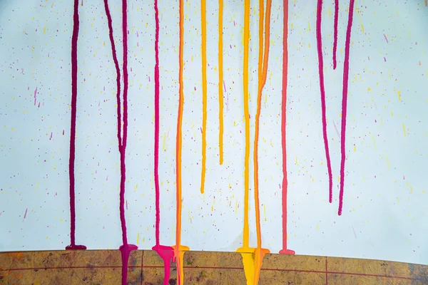 colors of printing ink purple, pink, orange, yellow and magenta colors are dripping on white paper.