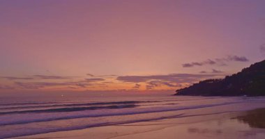 Mor gökyüzünün altında sakin okyanus dalgaları