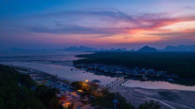 Alacakaranlıktaki Bang Phat balıkçı köyündeki gökyüzü manzarası. Mangrov ormanlarıyla çevrili küçük, ıssız bir adada yaşayan bir balıkçı köyündeki alacakaranlık gökyüzünün yansıması..