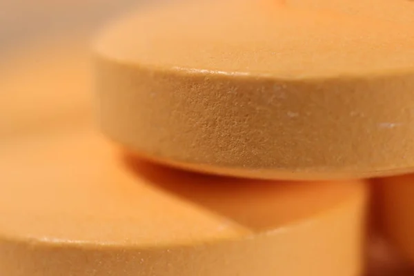 Orange Medicine Tablets Stacked on Top of Each Other. Pharmacy Pills Background. Macro Closeup.