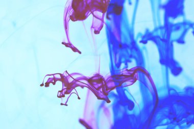 Kırmızı mavi mürekkep suya düşer. Arka plan.