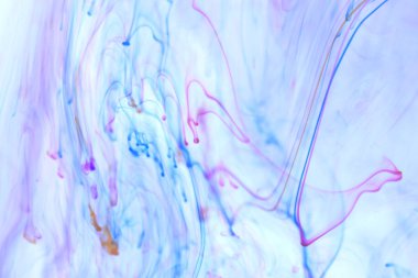 Renkli mürekkep damlaları dalgalar hareket dinamik suya düşüyor. Yumuşak ortam arka plan.