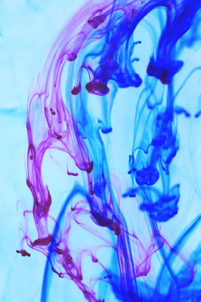 Düşen pembe mavi renkli mürekkep damlaları dinamik hareket. Ortam arka plan.