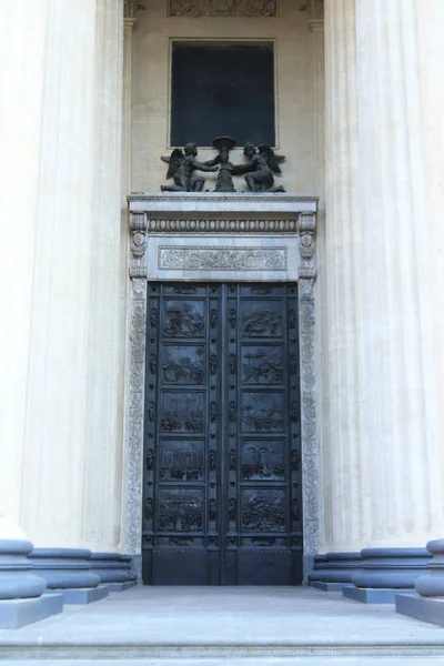 喀山大教堂的门装饰着装饰品和重要的历史事件 门上方有两个天使在一个黑色的广场附近拿着一个花瓶 圣彼得堡 — 图库照片
