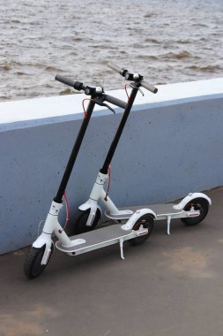 Neva Nehri Dolgu üzerinde park etmiş iki beyaz elektronik scooter