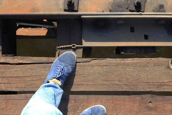 Men\'s feet on the railway bridge