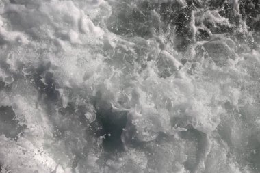 Deniz aqua devinim yüzey arka plan. Açık su köpük zemin swirls. Deniz dalga köpüğü doku.