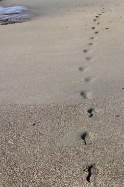 Ayak izleri mesafe içine kum dokusu üzerinde git. Yaz plaj arka plan.