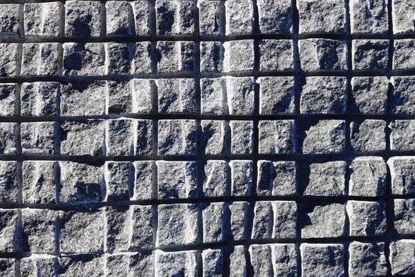 Sawn in a squares blue granite wall texture. Granite surface background.