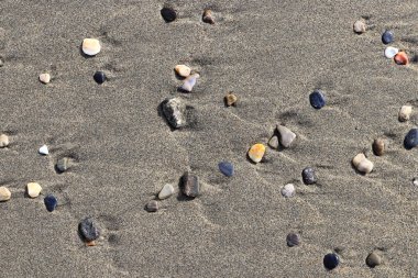 Farklı taş ıslak kum üzerinde. Nadir çakıl arka plan. Plaj güzellik zemin.