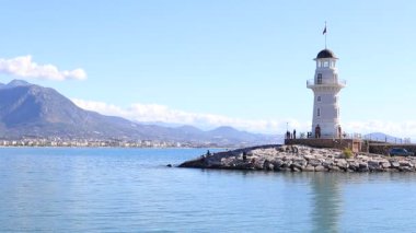 Beyaz deniz feneri ve arka plan üzerinde dağ deniz manzarası. Alanya. Türkiye.