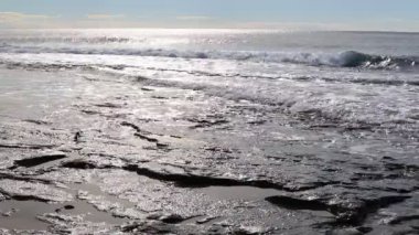 Cliff kıyı güneş ışığı yansıması ile sakin sıçramasına dalga üzerinde arka plan deniz manzarası.