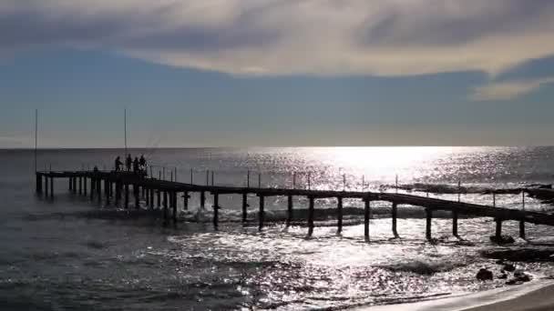 Рибалки Порожньому Пірсі Ловлять Рибу Відбиття Сонячного Світла Прийдешньому Морі — стокове відео
