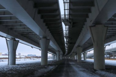 Köprü büyük beton yapım aşamasındadır. Perspektif görünümü. Soğuk kış manzarası.
