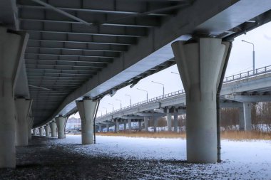 Köprü büyük beton yapım aşamasındadır. Perspektif görünümü. Soğuk kış manzarası.