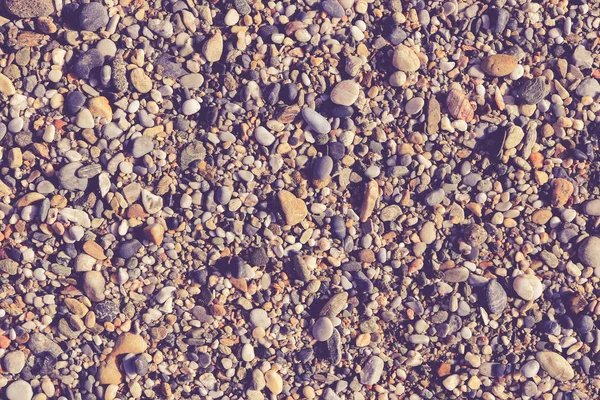 Muitas pedras pequenas na praia com pouca textura de seixos. Na — Fotografia de Stock