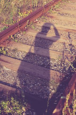 Demiryolu yolundaki insan gölgesi. Mistik gezgin uzun yol arka plan.