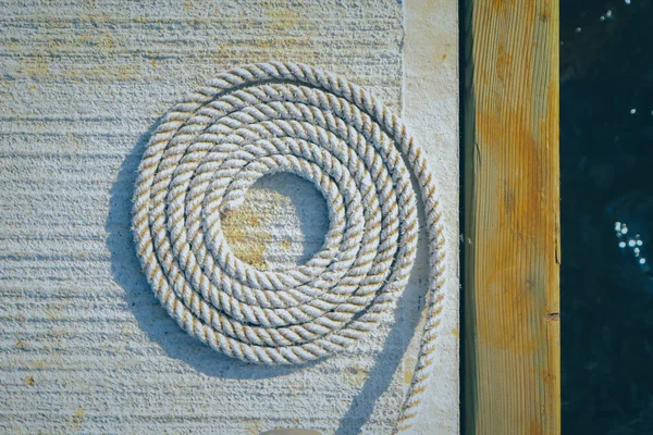 Roda fundo da embarcação corda. Corda em espiral marinha no cais. Corda caracol textura náutica . — Fotografia de Stock