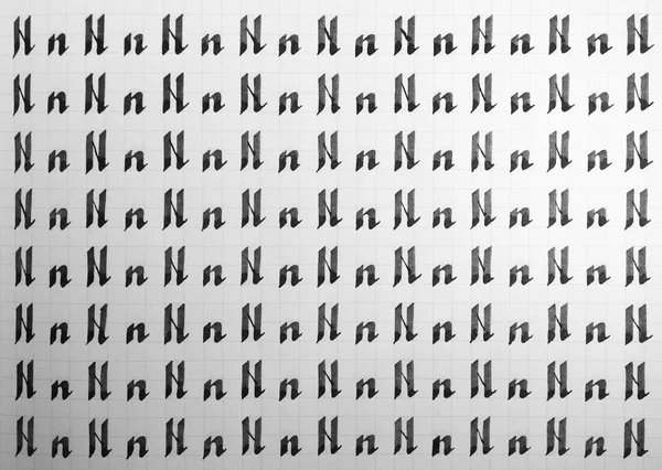 Handschrift zwart-wit symbool vulling patroon. Kalligrafische letter N leervaardigheden papier pagina. Kalligrafie letters n achtergrond. Belettering praktijk schrijven werkblad. — Stockfoto