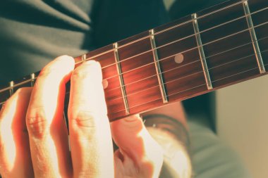 Gitar çalıyorum. Gitaristin el dinamiği hareketi. Müzikal yaşam tarzı arka planı. Makro yakın çekim.