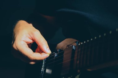 Müzikal yaşam tarzı arka planı. Gitar çalıyorum. Gitaristin el dinamiği hareketi. Makro yakın çekim.