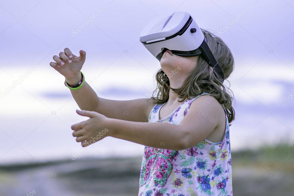 Little girl playing with a virtual reality glasses