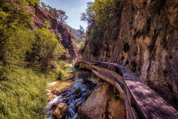 Duvarın yanındaki ahşap yol nehirden kaçıyor.