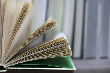 Açık kitap, masada ciltli kitap yığını. Üstten Görünüm.