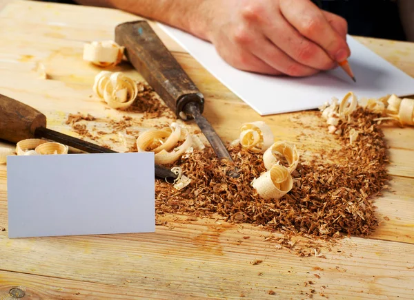 Visitekaartje op houten tafel voor timmerman tools met zaagsel. — Stockfoto