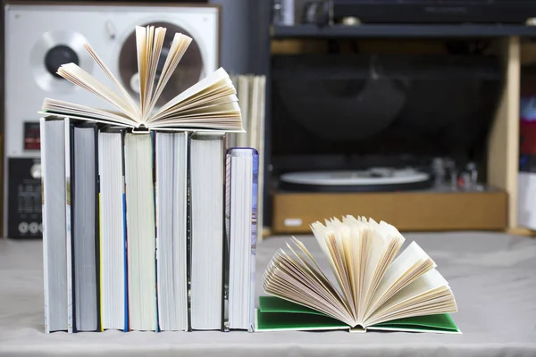 Libretto aperto, pila di libri rigidi sul tavolo. Vista dall'alto . — Foto Stock