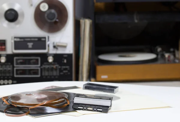 Vinyl record with copy space in front of a collection albums dummy titles. Reel Tape Recorder. Audio cassetes tap. — Stock Photo, Image