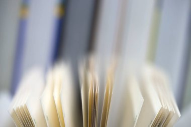Açık kitap, masada ciltli kitap yığını. Üstten Görünüm.