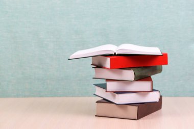 Açık kitap, ahşap masa üzerinde ciltli kitap yığını. Okula dönüş. Kopya alanı