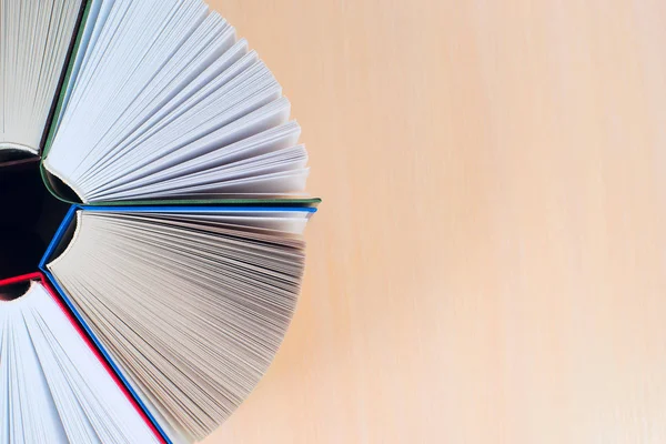 Açık kitap, ahşap masa üzerinde ciltli kitap yığını. Okula dönüş. Kopya alanı