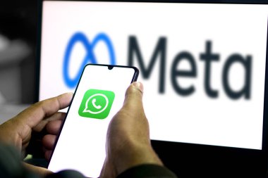 Amerikan teknoloji şirketi Meta Platform Inc. 'in harfleriyle akıllı telefonu elinde tutan kişi WhatsApp logosu önünde ekranda, telefon ekranına odaklan, Dhaka, Bangladeş 03 Nisan 2024.