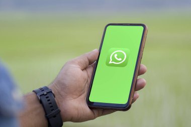 Ekranda WhatsApp olan bir cep telefonu tutan adam, Dhaka, Bangladeş - 17 Mart 2024.