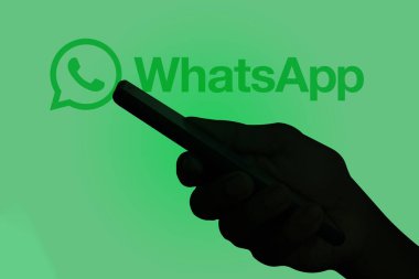 Ekranda WhatsApp olan bir cep telefonu tutan adam, Dhaka, Bangladeş - 17 Mart 2024.