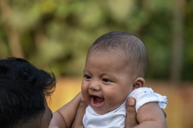 Bebek dışarıda beklerken mutlu bir şekilde gülümser.
